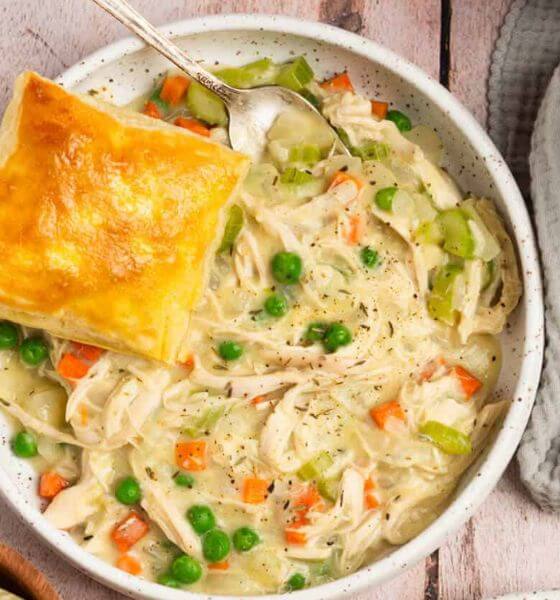 Deconstructed chicken pot pie in white bowl with spoon