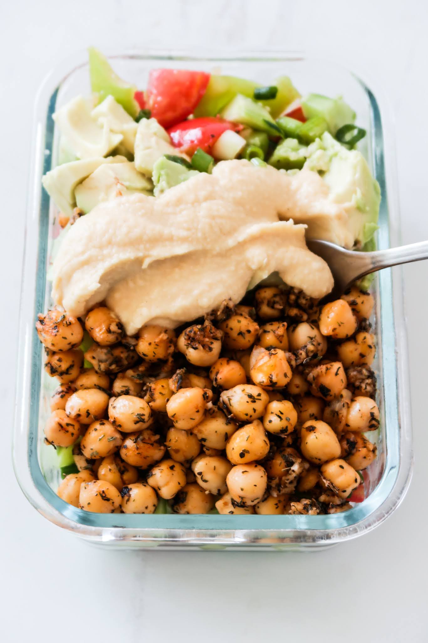 spicy mediterranean lunch bowls with chickpeas, hummus, avocado and cabbage salad